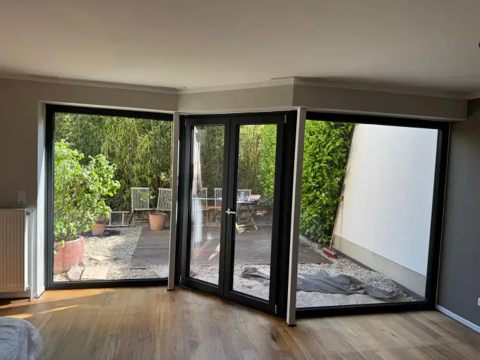 Großflächige Hebeschiebetür mit Blick in den Garten in einem modernen Wohnzimmer