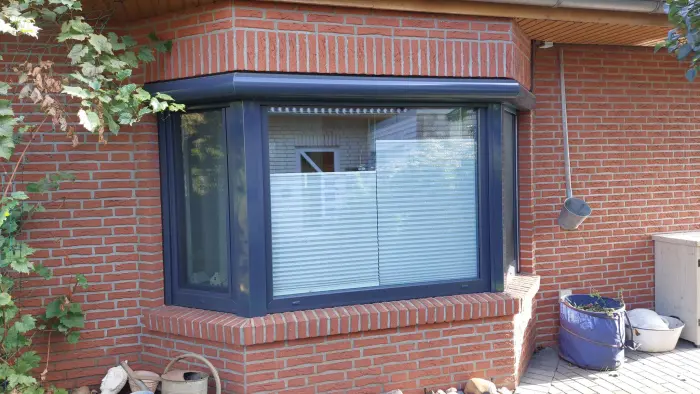 Erkerfenster mit anthrazitfarbenem Rahmen an einem Klinkerhaus