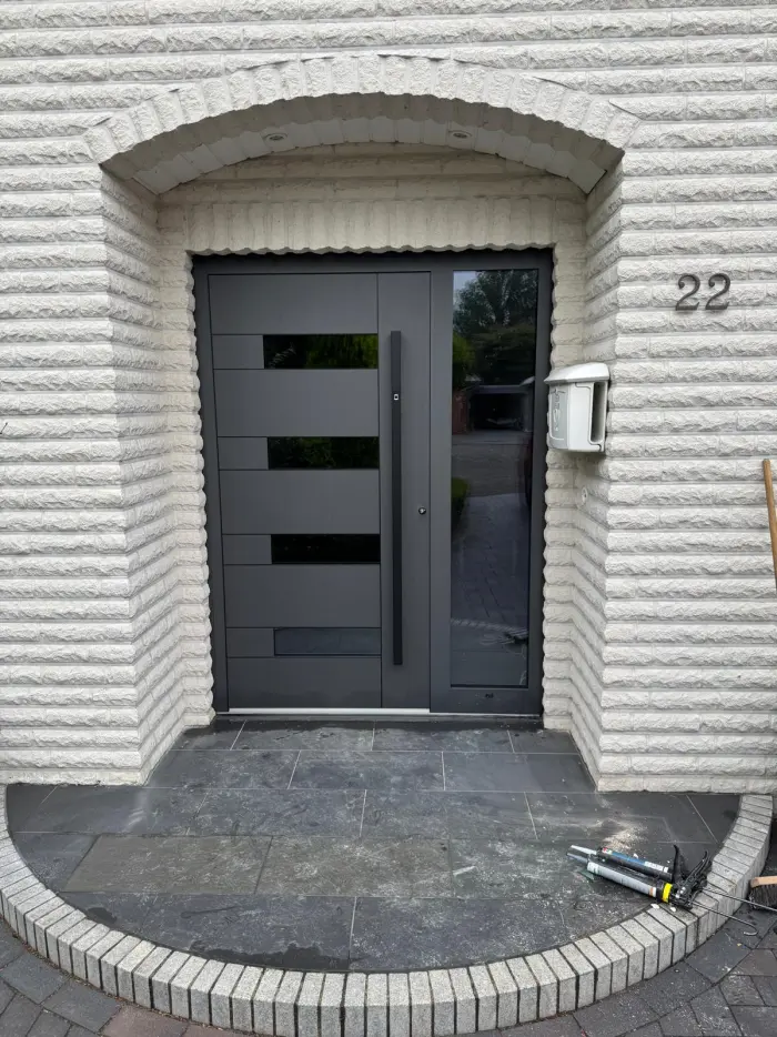 Moderne anthrazitfarbene Haustür mit Glaseinsatz und Edelstahlgriff
